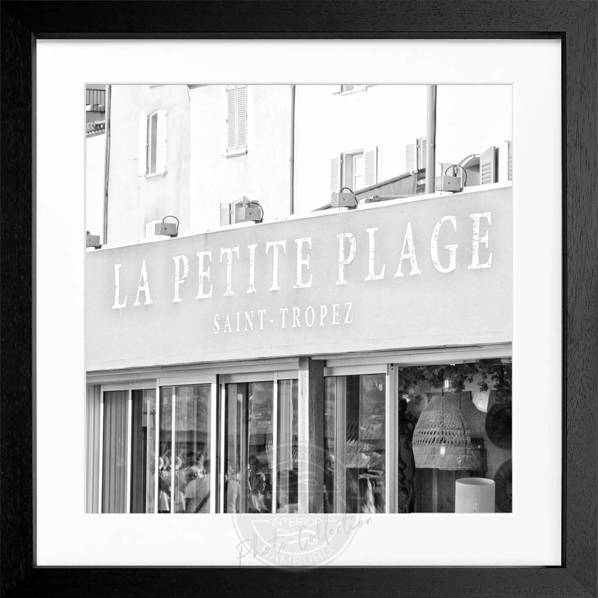 Schwarzes und weißes quadratisches Poster mit Rahmen, zeigt ein Bild von La Petite Plage in Saint Tropez von Cosman-Photocollection.