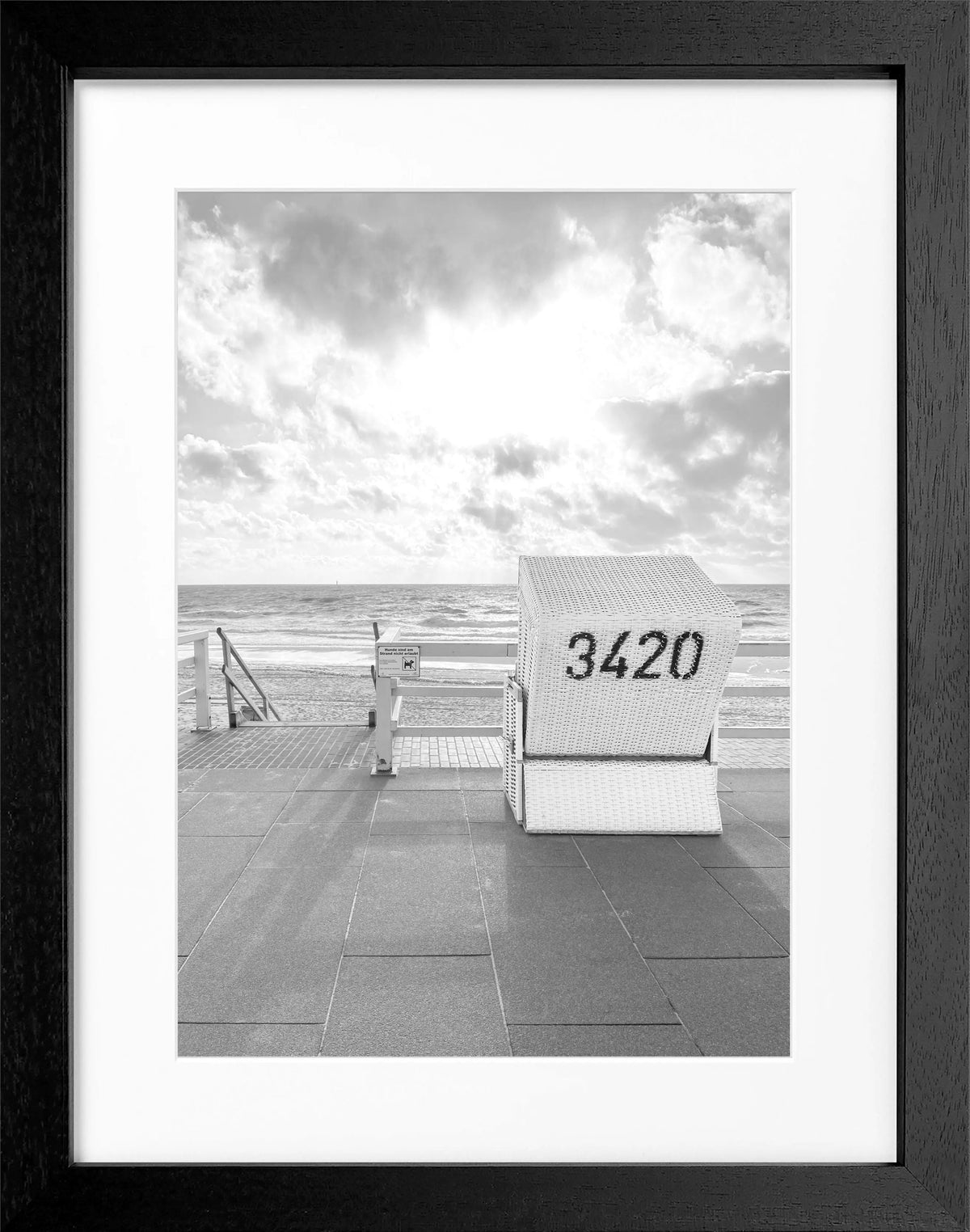 Schwarz-weiß Poster mit Rahmen, zeigt einen Strandkorb in Westerland auf Sylt, von Cosman-Photocollection, 25x31 cm.
