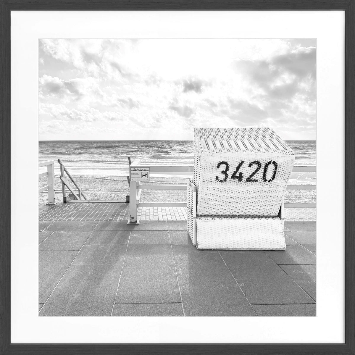 Schwarz-weiß Poster mit Rahmen, zeigt einen Strandkorb am Westerland Strand auf Sylt, von Cosman-Photocollection, quadratisch 55x55 cm.
