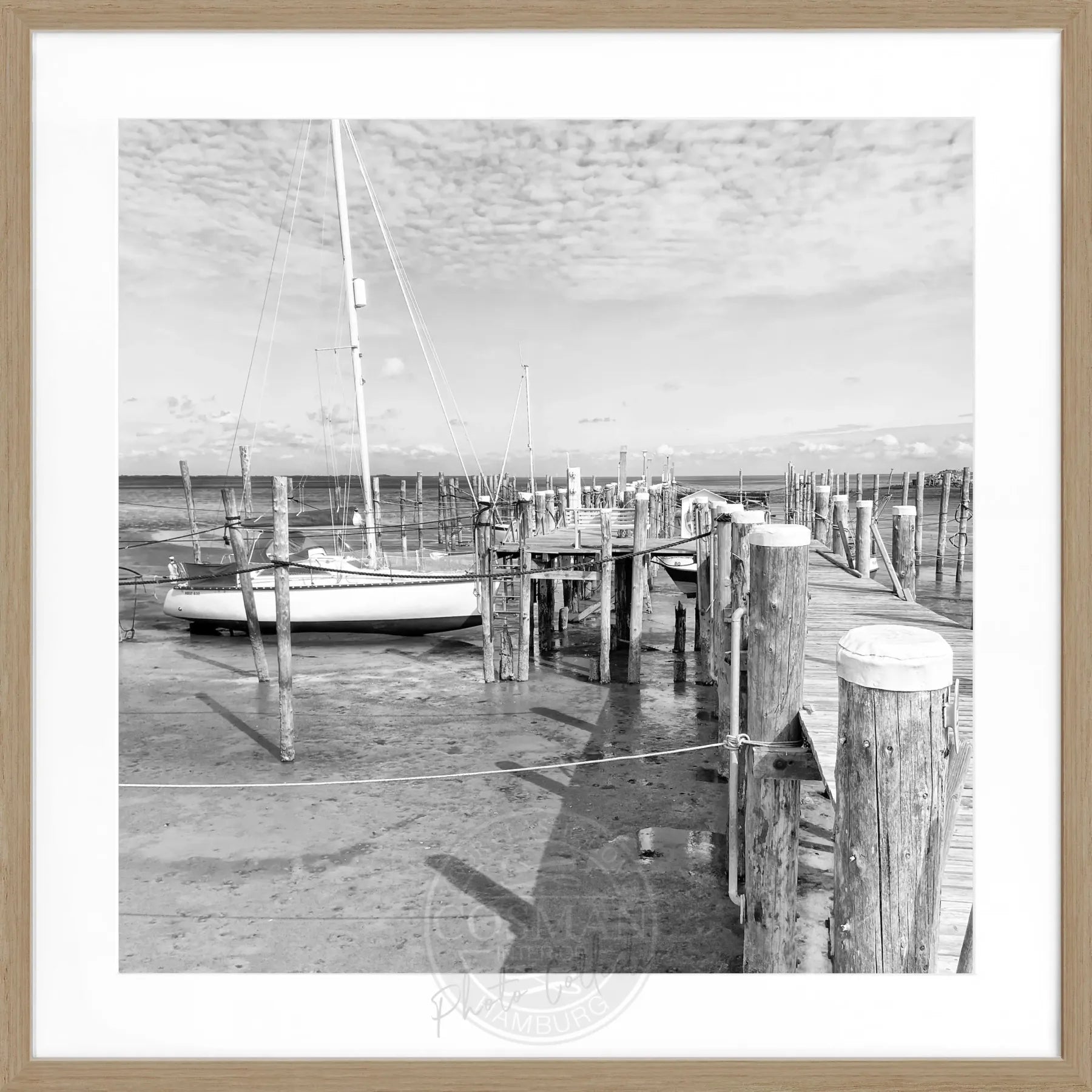 Schwarz-weiß Poster mit Rahmen von Cosman-Photocollection, zeigt den Hafen Rantum auf Sylt mit Steg, quadratisches Format 55x55 cm.