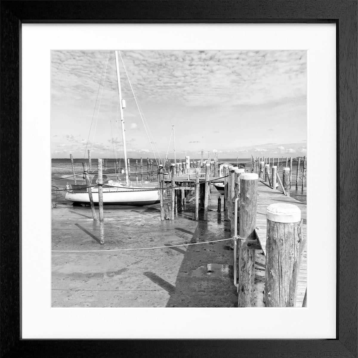 Schwarz-weiß Poster mit Rahmen von Cosman-Photocollection, zeigt den Hafen Rantum auf Sylt mit Steg, quadratisch 55x55cm.