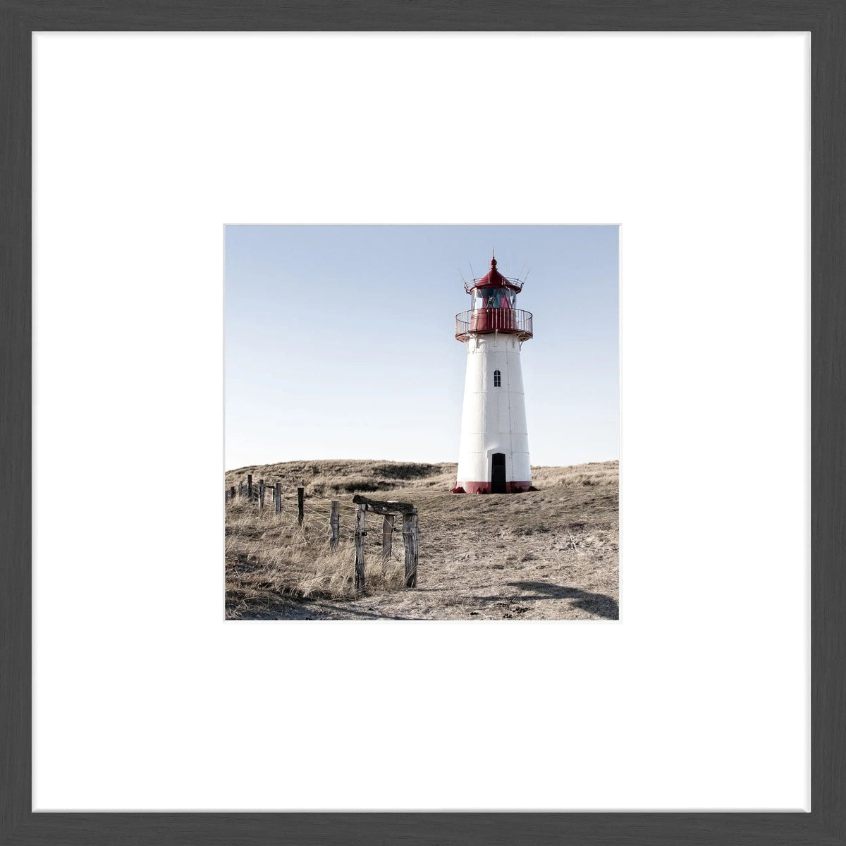 Schwarz-weißer Poster mit Rahmen ‘Leuchtturm List West’ Sylt, 43x43cm, von Cosman-Photocollection, an Wand in einem Objektrahmen.